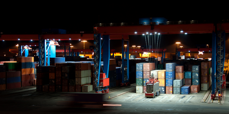 multicoloured containers lit by a bright spotlight at a port