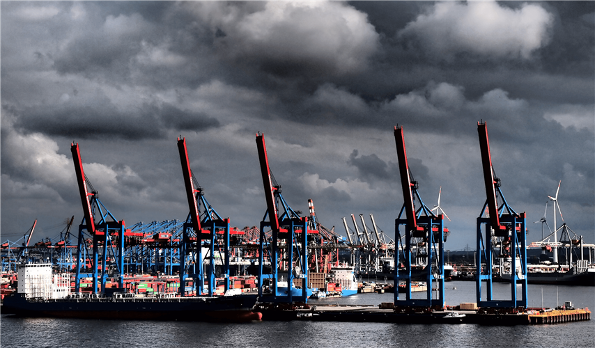 dark clouds loom over a port with cranes_s
