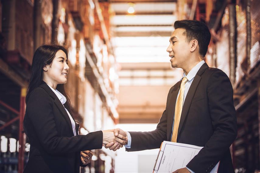 Business Woman In Suit Shaking Hand Of Businesses Man In Suit With Files In His Hand Optimized